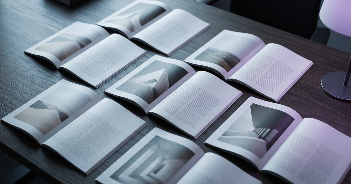 Open magazine spreads fanned across a desk, each one carrying a large photograph.