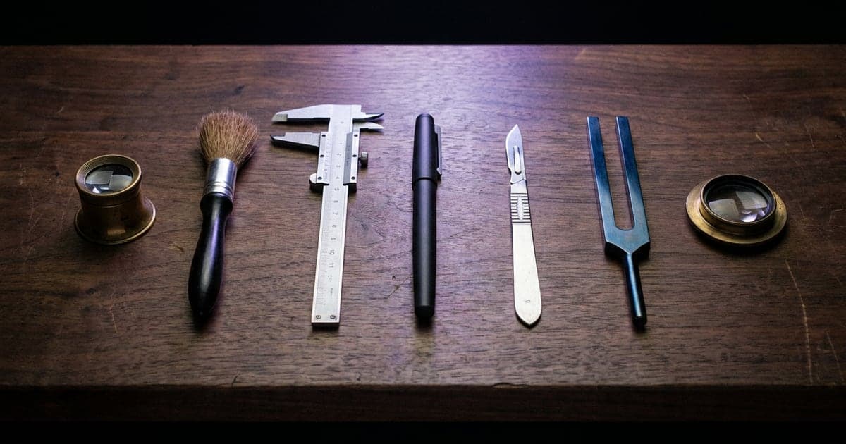 A row of different precision instruments on a dark workbench, each one made for a single job, one lit brighter than the rest.