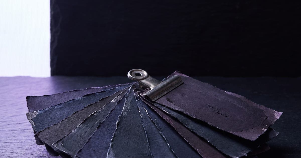A set of mixed paint chips clipped together, all variations of one colour.